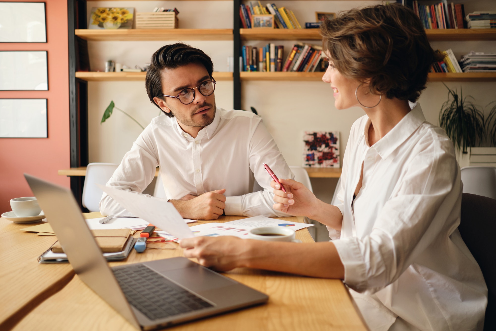 Young attractive business colleagues thoughtfully discussing new